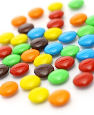 Beyaz arka plan üzerinde renkli şekerler bir sürü yayıldı