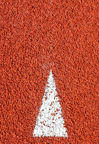 Um sinal de seta na pista de corrida — Fotografia de Stock