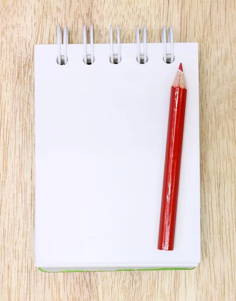 Lápis de cor e notebook sobre madeira — Fotografia de Stock