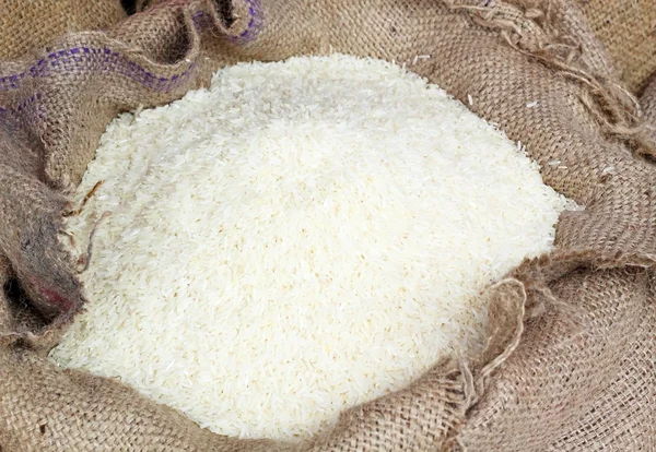 Vit lång ris i säckväv säck — Stockfoto