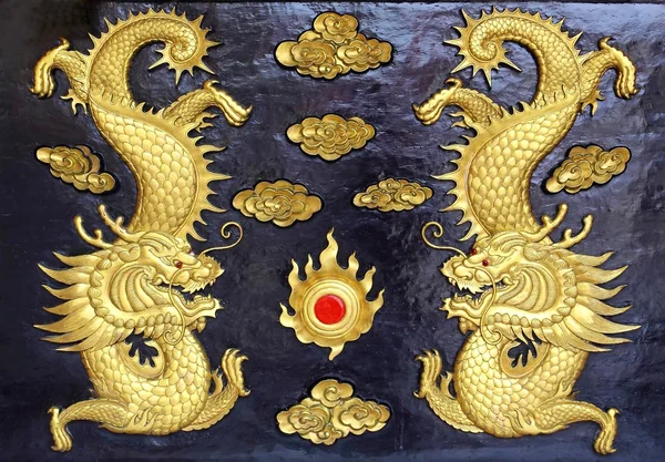 Two golden dragons (Chinese: Long) wood carving in black backgro — Stock Photo, Image