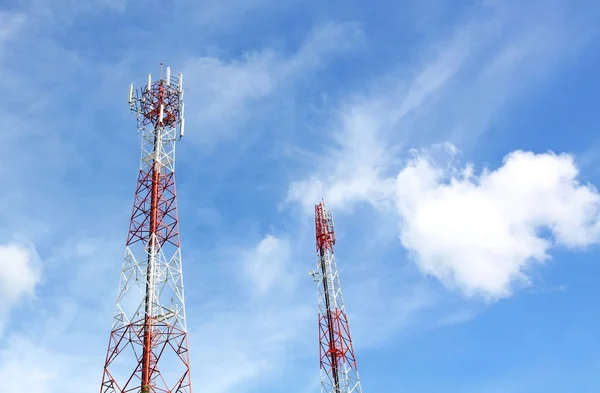 Cell phone and communication towers against blue sky with scatte — Stock Photo, Image