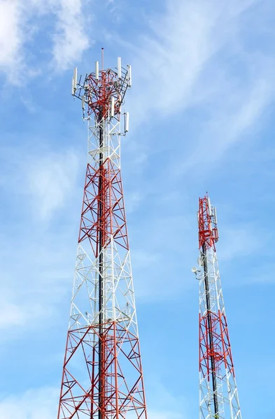 Telefone celular e torres de comunicação contra o céu azul com scatte — Fotografia de Stock