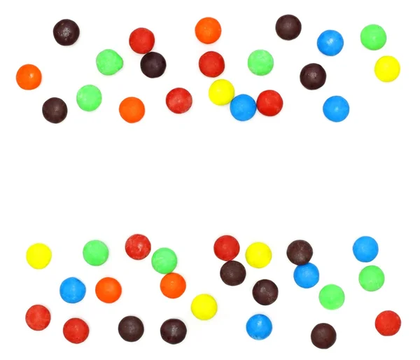 Lotes de doces coloridos espalhados no fundo branco — Fotografia de Stock