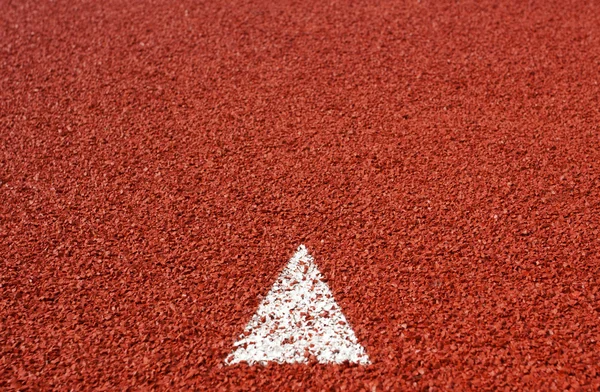 Signo de flecha en pista de atletismo goma cubierta textura para fondo — Foto de Stock