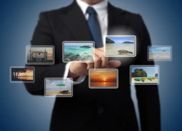 Forretningsmann som skyver virtuell skjerm med forskjellige bilder av – stockfoto
