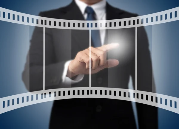 Geschäftsmann berührt Filmstreifen-Ikone — Stockfoto