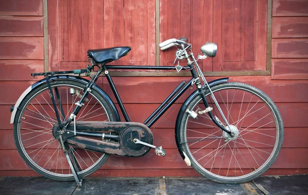 Bicicleta Vintage parada cerca de una pared de madera vintage —  Fotos de Stock