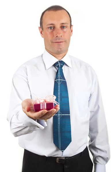 Porträt eines jungen Geschäftsmannes überreicht eine Schachtel mit einem Geschenk in der Hand — Stockfoto