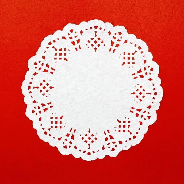Un papel redondo de patrón blanco sobre fondo rojo —  Fotos de Stock