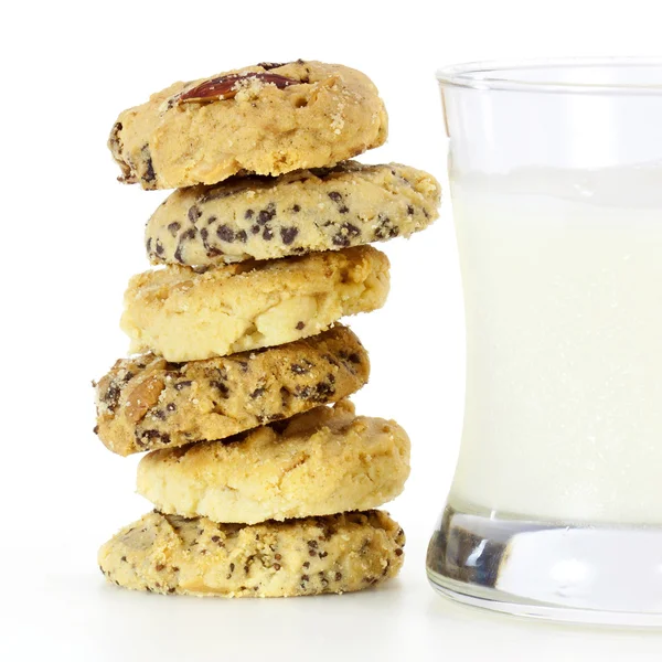 A stack of mixed fruit cookies and glass of milk — Stock Photo, Image