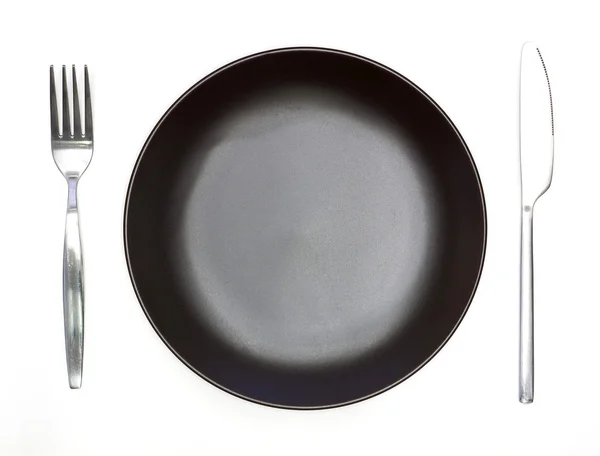 Cuchillo, plato marrón oscuro y tenedor aislado sobre fondo blanco —  Fotos de Stock