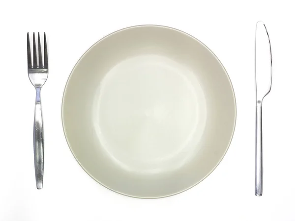 Cuchillo, plato crema y tenedor aislados sobre fondo blanco — Foto de Stock