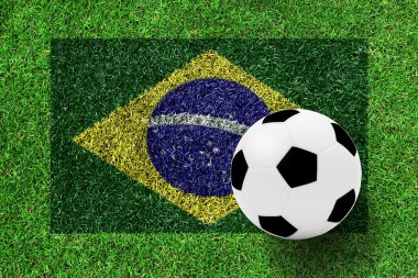 Yeşil çimenlerin üzerinde bir resim olarak Brezilya bayrağı futbol topu