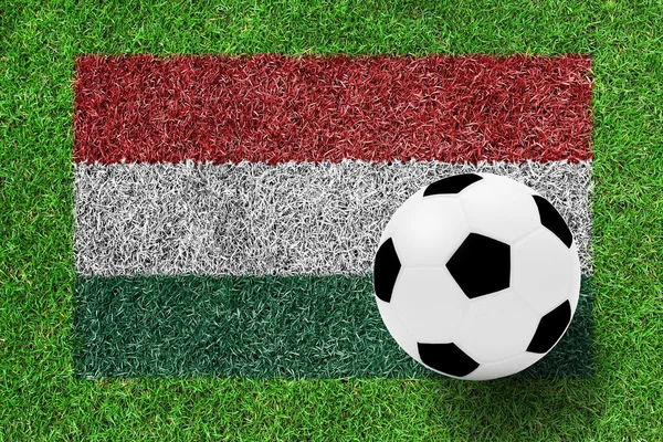 Soccer ball on Hungary flag as a painting on green grass — Stock Photo, Image