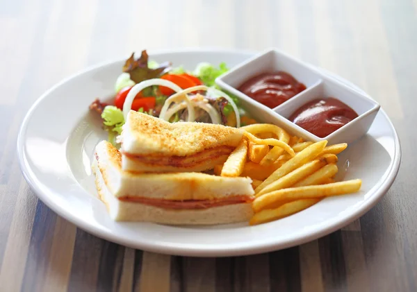 Delicious club sandwich with french fries and salad — Stock Photo, Image