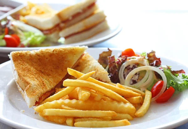 Delicious club sandwich with french fries and salad — Stock Photo, Image