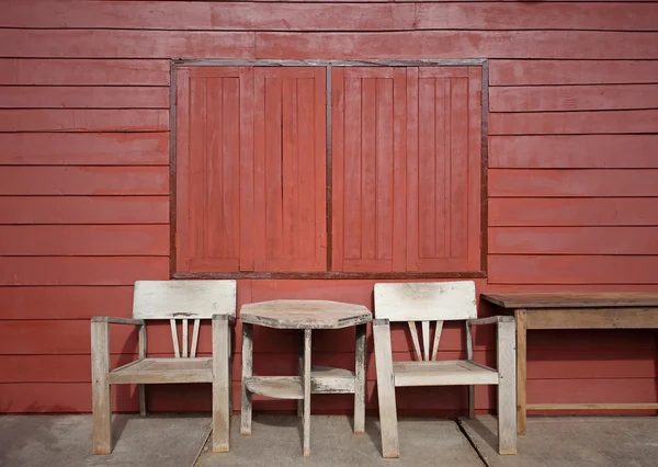 Old wooden chair against wooden wall — Stock Photo, Image