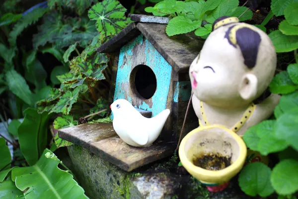 Old blue bird house with ceramic bird and boy — Stock Photo, Image
