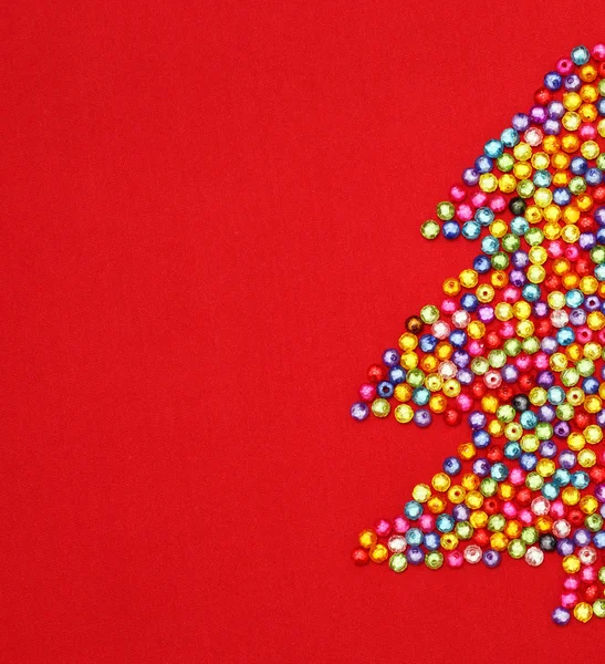 Albero di Natale decorare da perline colorate su sfondo rosso — Foto Stock