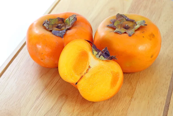 Świeże, dojrzałe persimmon na drewno — Zdjęcie stockowe
