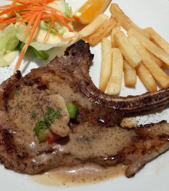 Kızarmış domuz pirzolası, cips ve sebze salatası