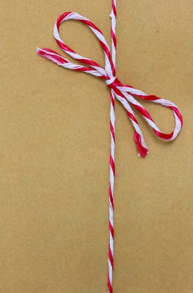 String amarrado em um arco, sobre embalagem de papel marrom . — Fotografia de Stock