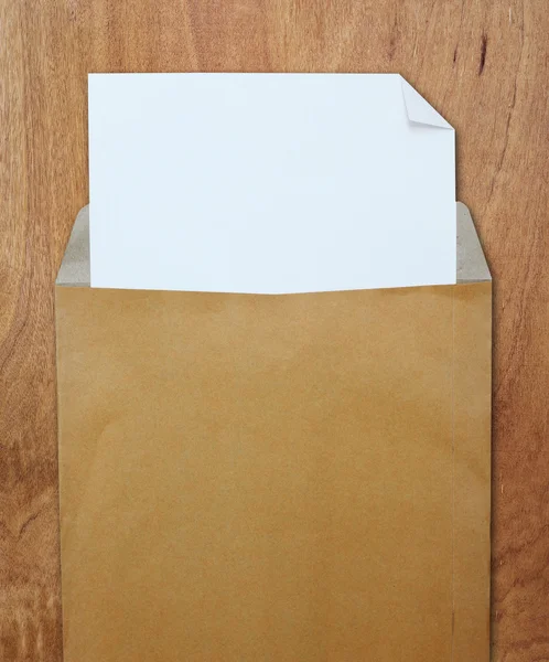 beyaz kağıt üzerine tahta arka plan ile kahverengi Zarfı açtı