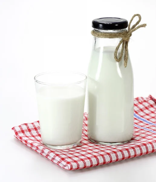 Ποτήρι γάλα και μπουκάλι σε άσπρο φόντο — Φωτογραφία Αρχείου