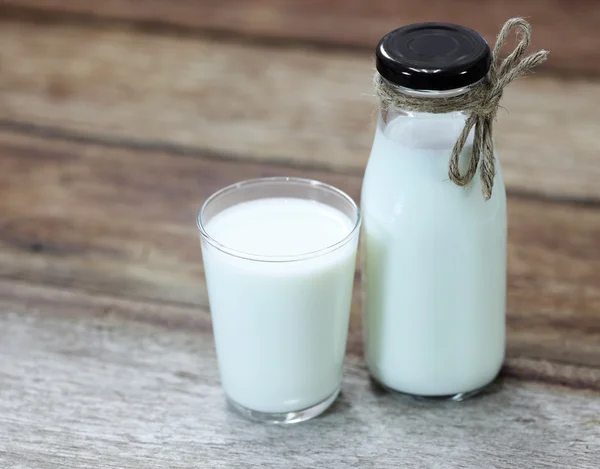 Bottle of fresh milk and glass on wooden table — Stock Photo, Image