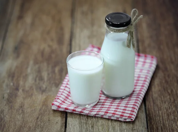 Μπουκάλι φρέσκο γάλα και το γυαλί στο ξύλινο τραπέζι — Φωτογραφία Αρχείου
