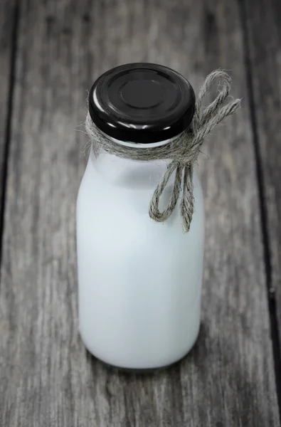 Milk bottle on wood table — Stock Photo, Image