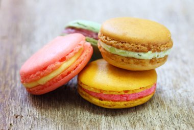 ahşap masanın üstüne yığılmış renkli Fransızca macaroons.