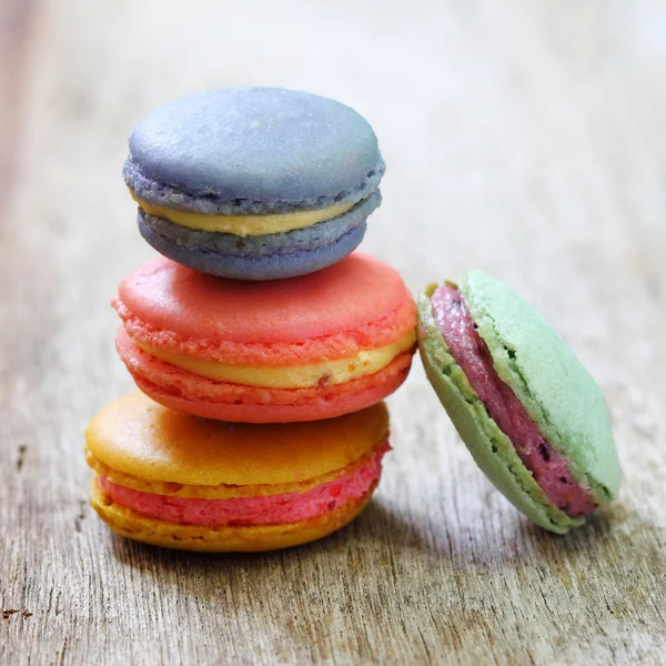 Colorful french macaroons stacked on wood table. — Stock Photo, Image