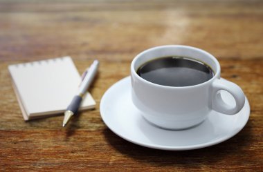 Kahve Kupası defter ve kalem ahşap tablo arka planı 