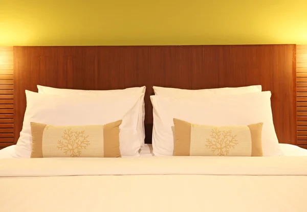 Empty bed with pillows and sheets in bedroom Stock Photo