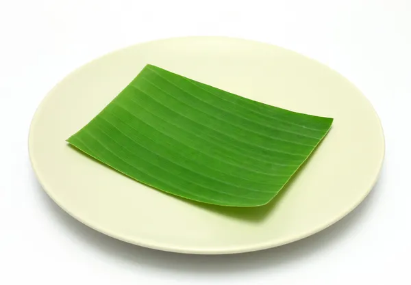 Hoja de plátano en el plato en blanco para editar alimentos o tema en —  Fotos de Stock