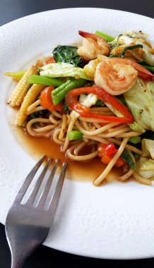 Deniz ürünleri ile kızarmış baharatlı makarna ilave edin 