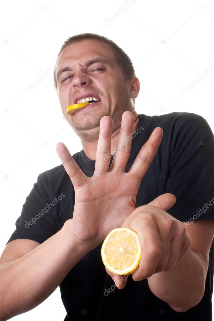Young man tasting lemon. thats sour