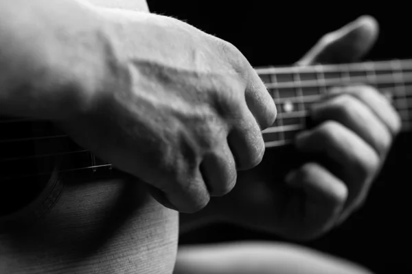 Guitarra nas mãos do tipo que a toca — Fotografia de Stock
