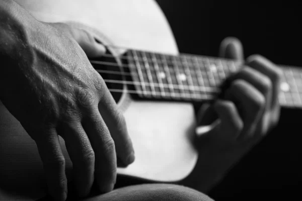 Guitarra nas mãos do tipo que a toca — Fotografia de Stock