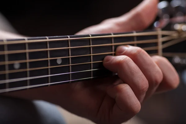 Guitarra marrón en las manos en el tipo que lo toca —  Fotos de Stock