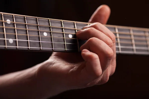 Guitarra marrón en las manos en el tipo que lo toca —  Fotos de Stock