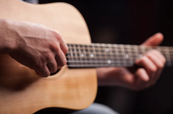 Kezében a srác játszik a barna gitár — Stock Fotó