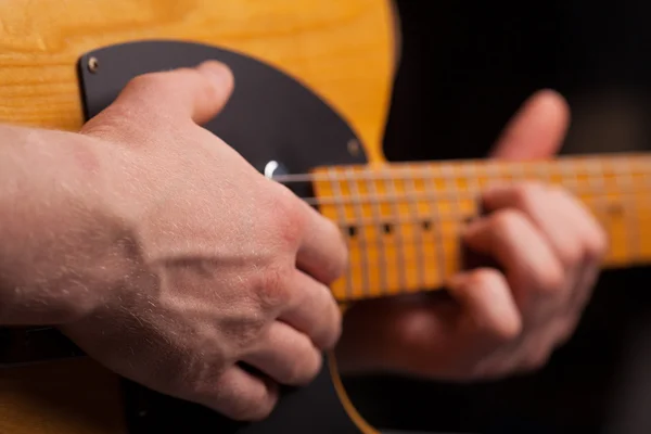 Guitarra castanha nas mãos do cara que joga — Fotografia de Stock
