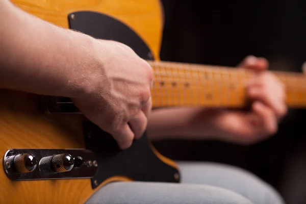 Guitarra castanha nas mãos do cara que joga — Fotografia de Stock