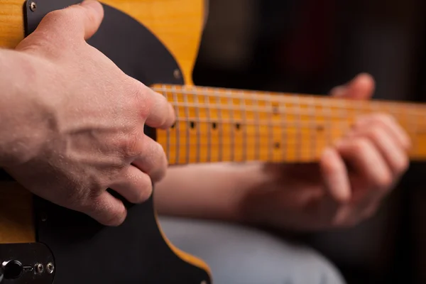 Guitarra marrón en las manos en el chico que juega jalá — Foto de Stock