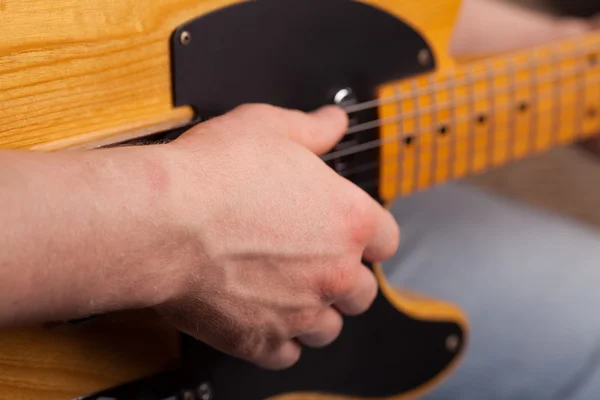 Коричневий гітару в руки в хлопцю грати? — стокове фото