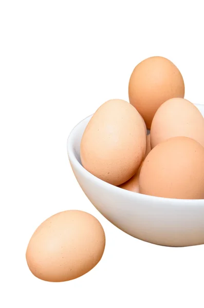 Eieren in witte kom op houten tafel — Stockfoto
