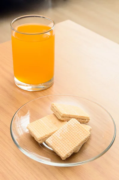 Succo d'arancia e wafer sul tavolo di legno — Foto Stock